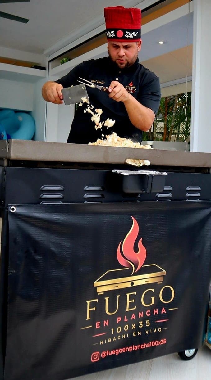 Chef Dexler lanzando arroz frito en el carrito de Fuego en Plancha
