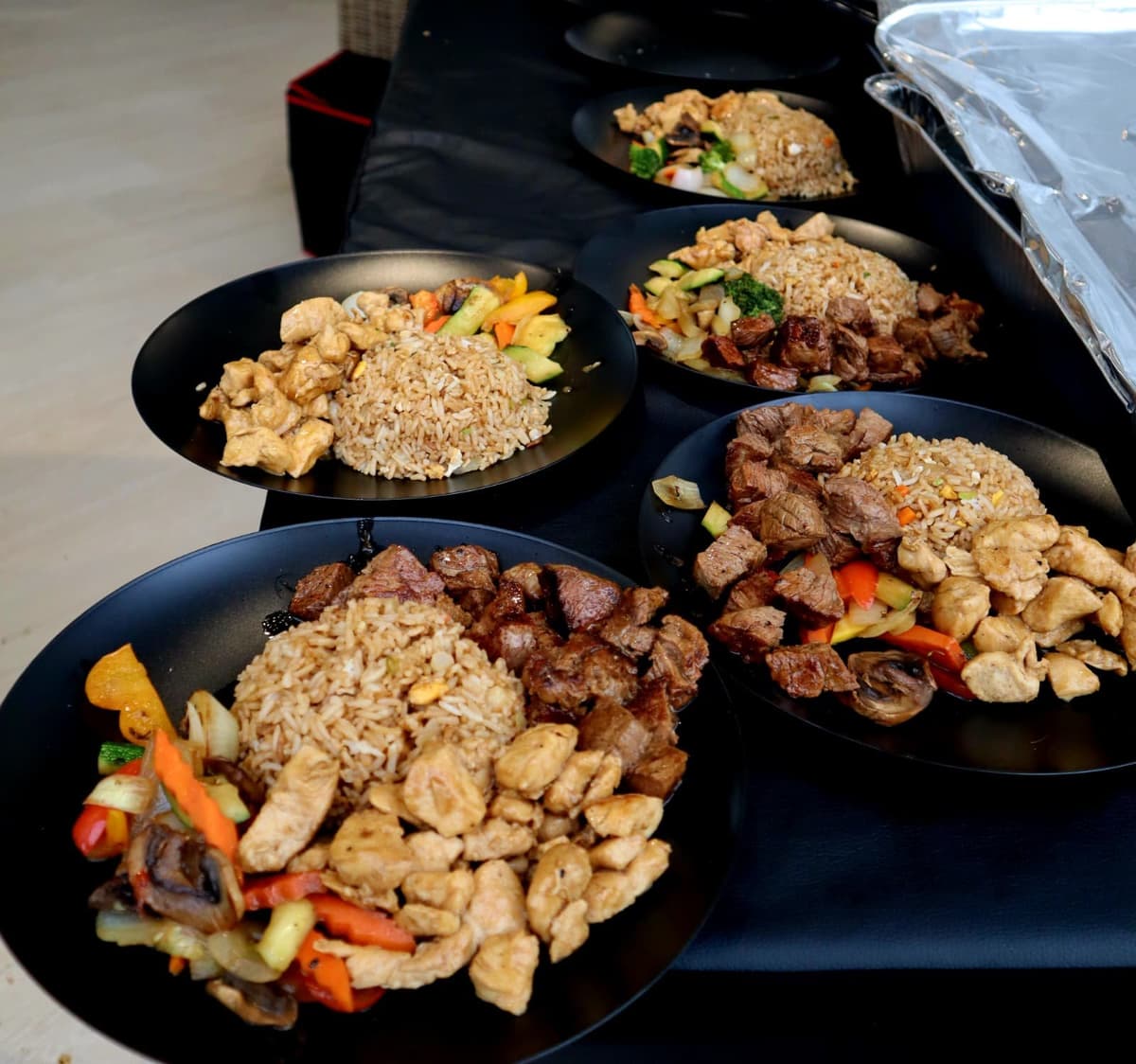 Platos de hibachi servidos: churrasco, pollo y arroz frito